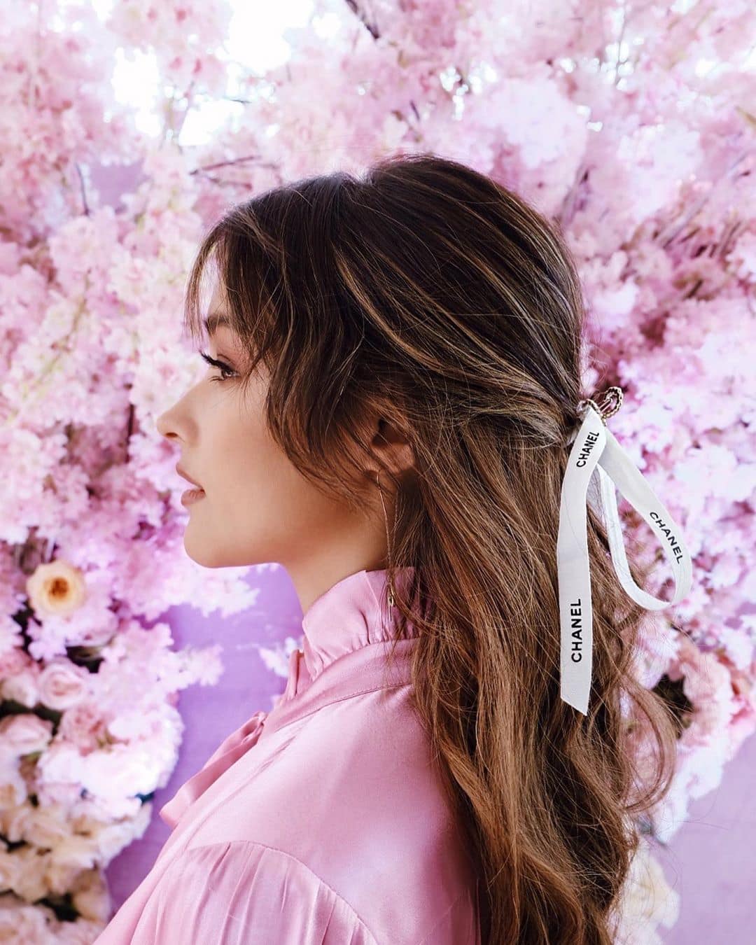 Tying your strands up with a Chanel ribbon is the newest cool-girl hair trend. Tying your strands up with a Chanel ribbon is the newest cool-girl hair trend.